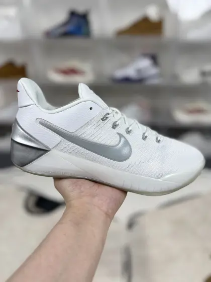 ▪️A版纯原 Nike Kobe AD Kicks Off New Year With Chrome 科比 圆头系带 低帮 实战篮球鞋 男款 白银 科比12代 ▪️ (39 40 40.5 41 42 42.5 43 44 44.5 45 46) ▪️货号:852427-110 ▪️Nike Kobe AD是科比·布莱恩特退役后推出的首款签名篮球鞋.以“实用主义为先”为理念,聚焦后卫球员的实战需求,强调灵活性、缓震与抓地力,适合快速变向、急停和突破动作.鞋面采用单片式加强网布或织物材质,搭配Flywire动态飞线技术,通过多组飞线在系带时形成动态锁定,提升脚面包裹性,防止脚在鞋内滑动.中底采用全掌Lunarlon泡棉结合后掌ZoomAir气垫的缓震方案.Lunarlon泡棉提供基础缓震和舒适性,ZoomAir气垫在后掌位置增强冲击吸收和回弹,适合后卫的快速起跳和落地动作.外底采用橡胶材质,纹路设计注重多向抓地力,通过增加接触面积和纹理深度,在木地板等室内场地提供出色的摩擦表现,适合快速切入和变向.Nike Kobe AD是一款以实用性和灵活性为核心的实战篮球鞋,适合后卫球员在室内场地使用,其缓震、抓地力和包裹性表现均衡,但脚踝保护性和耐磨性相对有限.